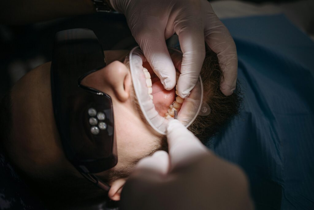 pexels photo 6812543 6812543 A dentist's hands examining a patient's teeth using specialized tools.